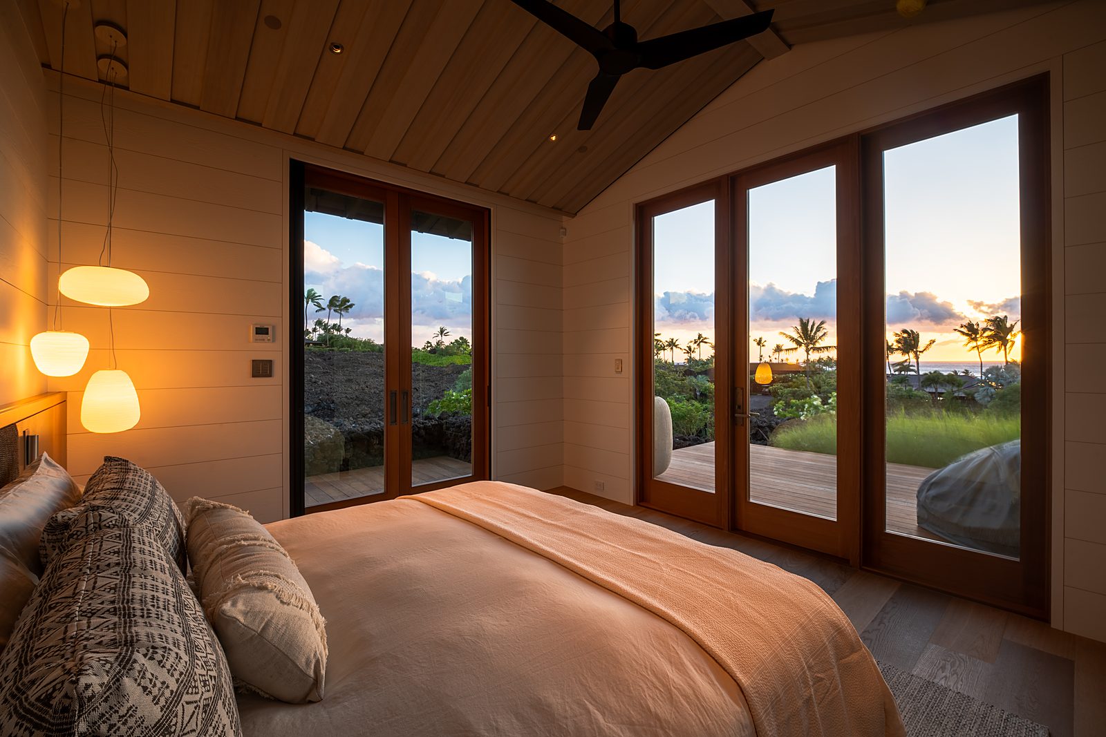Primary suite with paper lanterns and ocean view at sunset